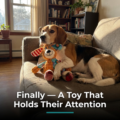 Dog resting on a couch while cuddling an orange plush dog-design toy indoors.