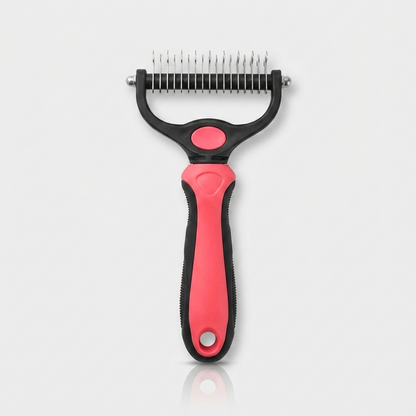 Red and black dual-sided dog deshedding brush and comb standing upright on a white background, showing the stainless steel dematting blades and ergonomic handle.