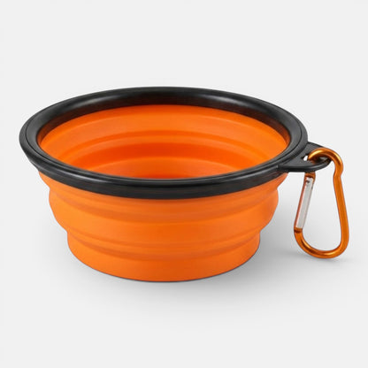 An orange collapsible silicone travel bowl for dogs shown open on a plain background.