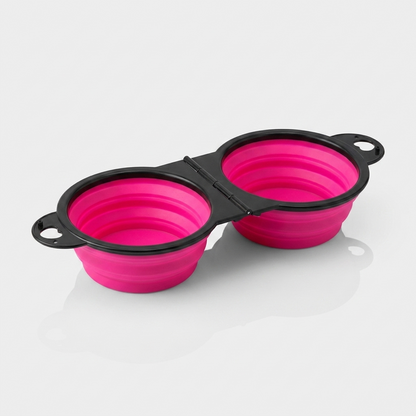 A pink foldable dual bowl feeder sits open and ready for food and water.