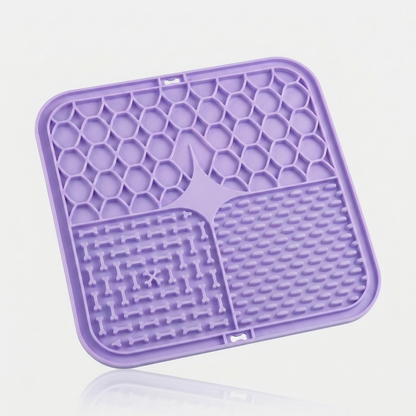 Purple silicone lick mat for dogs with three textured feeding zones, shown at an angle on a white background.