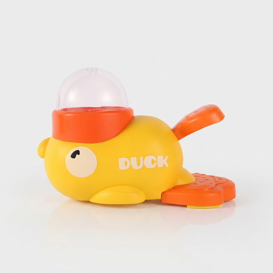 Yellow duck-shaped treat dispenser slow feeder toy with orange feet and a clear dome top, shown from the side on a plain white background.